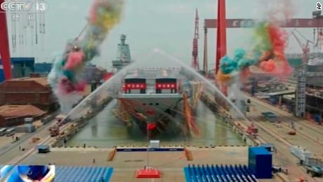 In this image taken from China&#39;s state broadcaster CCTV, water cannons spray China&#39;s third aircraft carrier Fujian during its launching ceremony at a dry dock in Shanghai on Friday.