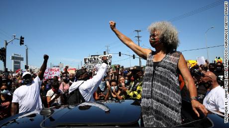 Civil rights icon Angela Davis pumps her fist in solidarity during a Juneteenth protest against police brutality  in Oakland, California, in 2020.