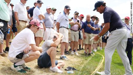 Mickelson takes care of a fan hit by his ball on the third hole.