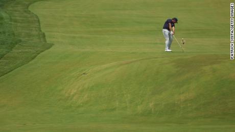 Mickelson plays an approaching shot at the ninth hole.