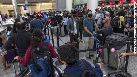 Travelers wait to check-in in the international terminal at San Francisco International Airport (SFO) in San Francisco, California, US, on Monday, June 13, 2022. The Biden administration is lifting its requirement that all travelers test negative for coronavirus before flying to the US, amid pressure from airlines that viewed the measure as excessive and blamed it for depressing ticket purchases. 