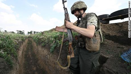 A Ukrainian soldier walks through a trench towards a Ukrainian army position between the southern cities of Mykolaiv and Kherson on June 12, 2022, during the Russian invasion of Ukraine. 
