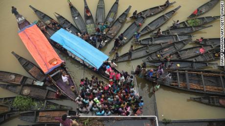 Menschen versammeln sich am Montag in einem überschwemmten Gebiet in Kumbanijang, Bangladesch, um Nahrungsmittelhilfe zu sammeln. 
