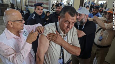 Een Palestijnse moslimpelgrim krijgt op 21 juni een dosis van een vaccin tegen Covid-19 bij de grensovergang van Rafah met Egypte, terwijl hij naar Saoedi-Arabië gaat voor de jaarlijkse hadj-bedevaart.
