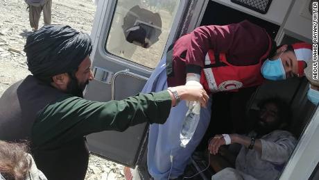 متطوعو جمعية الهلال الأحمر الأفغاني يساعدون الأشخاص المتضررين من الزلزال الذي ضرب منطقة غيان.