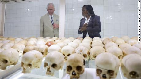 Książę Karol patrzy na czaszki ofiar masakry.