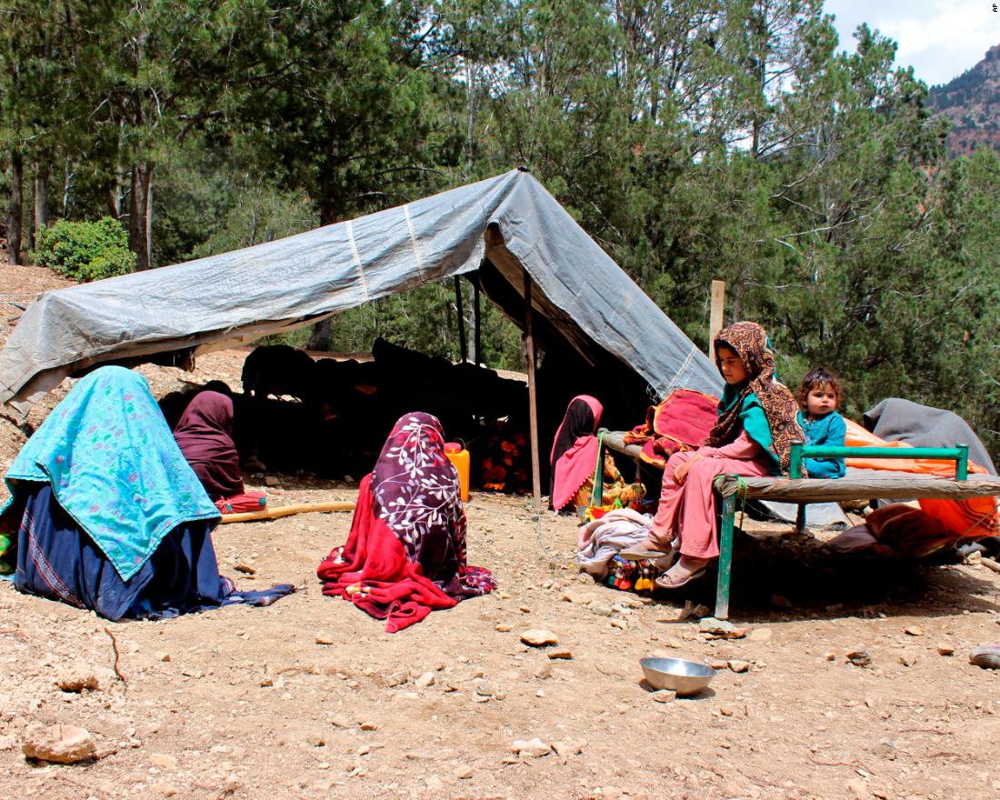 People sit outside a tent after their house was damaged in the earthquake on June 22.