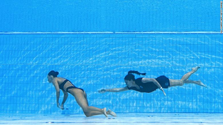 A member of Team USA (R) swims to recover USA&#39;s Anita Alvarez (L), from the bottom of the pool during an incident in the women&#39;s solo free artistic swimming finals, during the Budapest 2022 World Aquatics Championships at the Alfred Hajos Swimming Complex in Budapest on June 22, 2022.