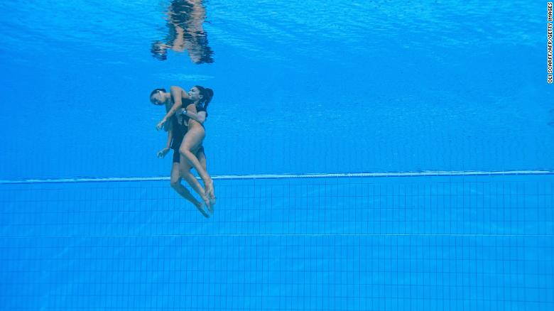 American artistic swimmer Anita Alvarez is rescued from the bottom of the pool by her coach, Andrea Fuentes, after her routine in the women's solo free artistic swimming finals at the 2022 FINA World Aquatics Championships in Budapest, Hungary, on June 22. 