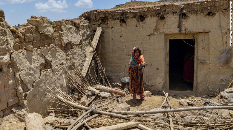 A child stands beside a house damaged by an earthquake in Bernal district, Paktika province, on June 23.