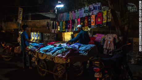 A cloth seller under emergency lighting is connected to a motorcycle during a power outage caused by a load in Karachi, Pakistan on June 8.