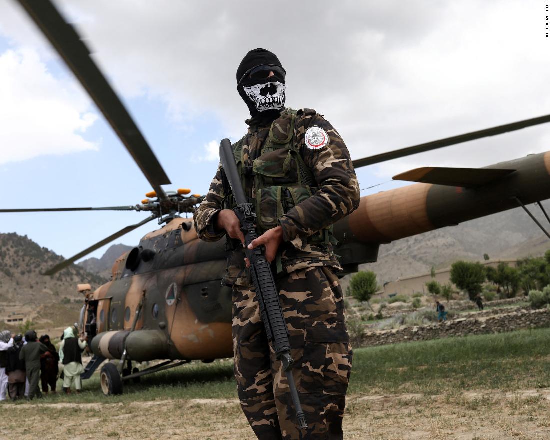 A Taliban fighter stands guard next to a helicopter in Gayan, Afghanistan, on June 23.