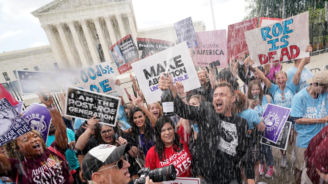 Anti-abortion demonstrators celebrate with champagne in front of the Supreme Court.