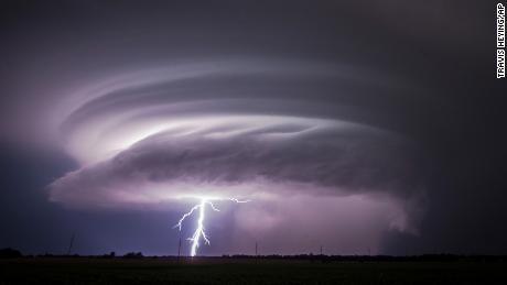 A lightning bolt emerges from a severe thunderstorm just west of Wichita, Kan., on Tuesday, June, 26, 2018. Multiple storms erupted over south-central Kansas on Tuesday. (Travis Heying/The Wichita Eagle via AP)