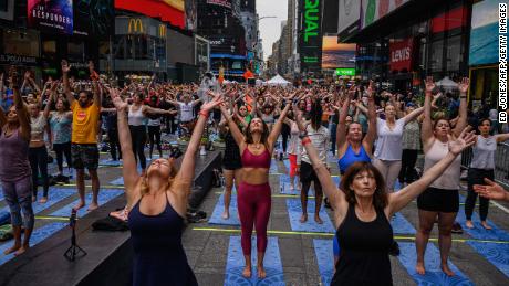 Los yoguis participan en un evento de soledad de verano en Times Square el martes.