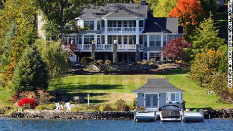 Lake Gorge, NY, USA - October 12, 2015: Taken this picture of the lavish residence on the bank of river bank. In this picture tried to capture the lifestyle of people and what can be said as dream house. In front is the speed boat anchored and sitout beside it; the lawn is nicely laid out; in backgrond is the lavish residence.