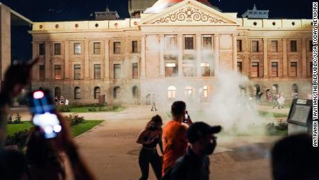 Arizona Eyalet Birlikleri, Capitol binasının dışında protestocularla karşı karşıya gelirken göz yaşartıcı gaz kullanıyor.