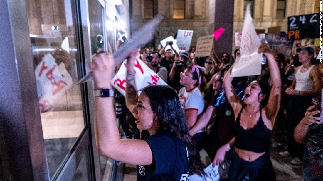 Abortion rights activists pound on the doors of the Arizona State Senate following the Supreme Court&#39;s decision to overturn Roe v. Wade.