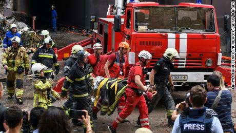 Los equipos de rescate evacuan a una persona de un edificio de apartamentos destruido en un ataque aéreo ruso en el distrito Shevchenkivsky de Kyiv el 26 de junio de 2022.