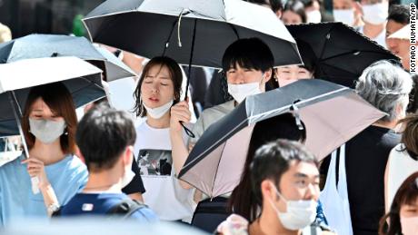 26 Haziran 2022'de Tokyo'nun Ginza semtinde yüz maskesi takan insanlar görülüyor. 