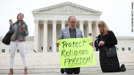 WASHINGTON, DC - APRIL 25: Demonstrators kneel in prayer outside the U.S. Supreme Court as the case of former Bremerton High School assistant football coach Joe Kennedy is argued before the court April 25, 2022 in Washington, DC. Kennedy was terminated from his job by Bremerton public school officials in 2015 after refusing to stop his on-field prayers after football games. 