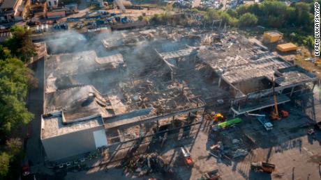 Οι πυροσβέστες εργάζονται για να καθαρίσουν τα ερείπια σε ένα εμπορικό κέντρο που κάηκε μετά από επίθεση με ρουκέτα στο Kremenchug της Ουκρανίας.