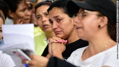 Kerabat narapidana di penjara Tulua di Kolombia menunggu di luar fasilitas setelah insiden mematikan pada hari Selasa. 