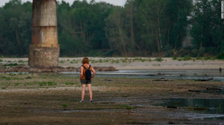 A woman stands on the Po riverbed next to Ponte della Becca (Becca bridge) in Linarolo, near Pavia, Italy, on June 27, 2022.