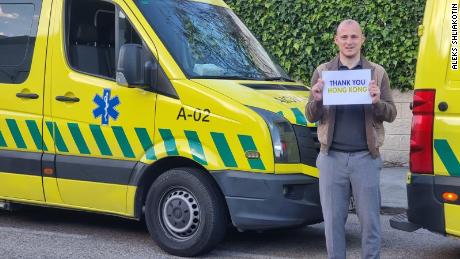 Ukrainian footballer Roman Zozulya holds a 'Thank You Hong Kong' sign in front of an ambulance to be sent from Spain to Ukraine.