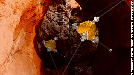 An artist's concept shows ReachBot exploring a Martian cave.