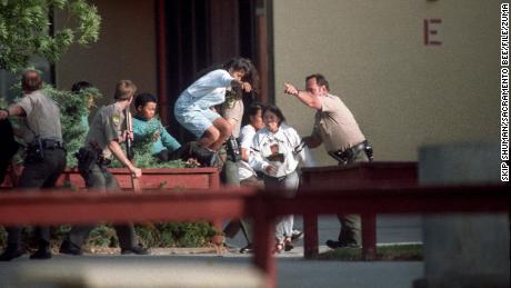 Officers evacuate students at Lindhurst High School in Olivehurst, California, after former student Eric Houston seized hostages on the campus on May 1, 1992. 


