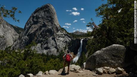 A tourist takes in Liberty Cap and Nevada Falls at Yosemite National Park in California.