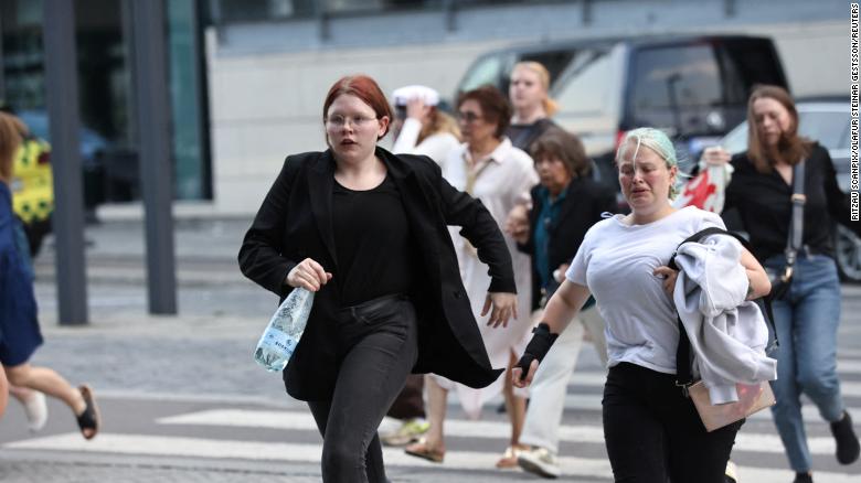 People run out of the Field's shopping center in Copenhagen, Denmark on July 3, 2022. 