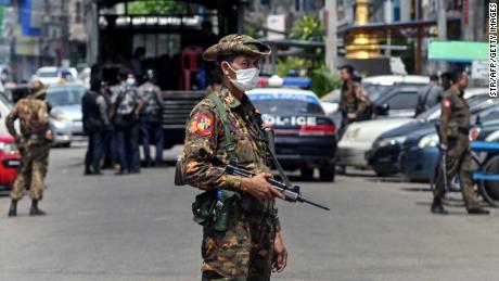 A soldier guards a road while security forces search for protesters in Yangon.