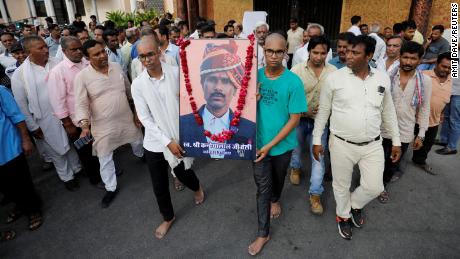 Two sons of Kanhaiya Lal Teli, the murdered Hindu tailor, carry a portrait of their father in Udaipur, Rajasthan, India, on June 30.