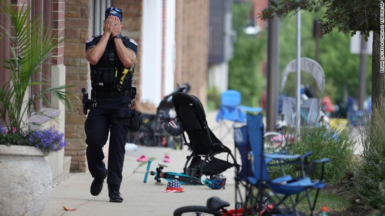 A Lake Forest police officer walks down Central Avenue in Highland Park, Illinois, on Monday, July 4. 