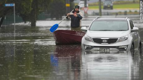 A man paddles his boat through a flooded street in Windsor, on the outskirts of Sydney, Australia, July 5, 2022.