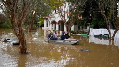 People paddle through a flooded street in Windsor, Australia, July 5, 2022