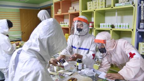 Anggota tentara Korea Utara memasok obat-obatan kepada penduduk di sebuah apotek di Pyongyang, di tengah meningkatnya kekhawatiran atas penyebaran virus corona, pada 18 Mei.