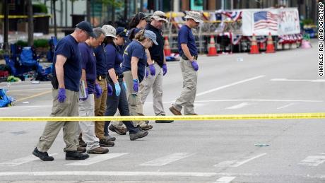 Members of the FBI's evidence response team walk the scene one day after a mass shooting in downtown Highland Park, Illinois, on Tuesday.