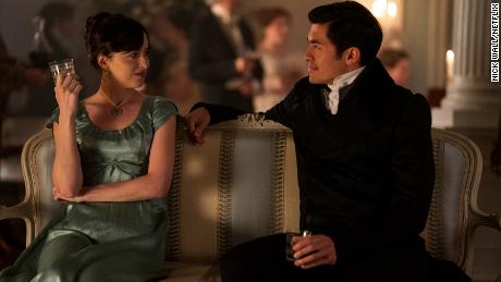 (From left) Dakota Johnson as Anne Elliot and Henry Golding as Mr. Elliot are shown in a scene from &quot;Persuasion.&quot;