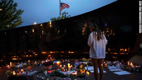   A woman views the candles and flowers left the victims of the parade shooting on July 5, 2022 in Highland Park.