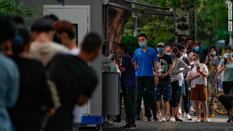 Les résidents font la queue pour subir un prélèvement de gorge sur un site de test à Pékin le 4 juillet.