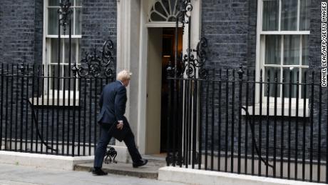 Britain&#39;s Prime Minister Boris Johnson walks back into 10 Downing Street in central London on July 7, 2022 after making a statement. - Johnson quit as Conservative party leader, after three tumultuous years in charge marked by Brexit, Covid and mounting scandals.