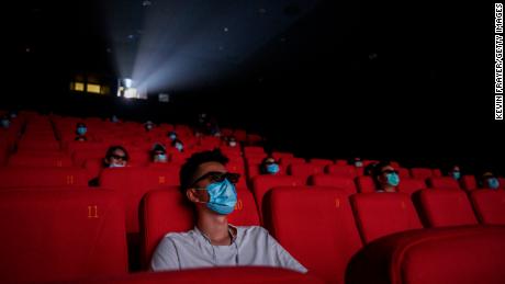People wearing protective masks as they watch a movie in 3D at a theater on the first day they were permitted to open in Beijing on July 24, 2020. China&#39;s box office became the world&#39;s largest that year, according to Comscore data.