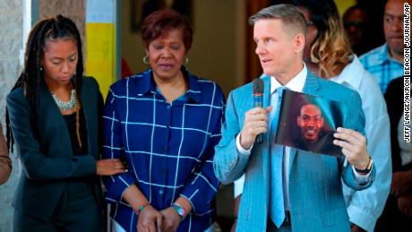 Attorney Bobby DiCello, right, holds up a photograph of Jayland Walker as attorney Paige White, left, comforts Walker's mother Pamela Walker during a June 30 news conference at St. Ashworth Temple in Akron.