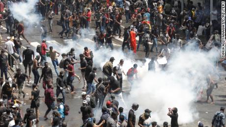 Protesters run away from tear gas used by police during a protest demanding the resignation of President Gotabaya Rajapaksa on Saturday near the presidential residence in Colombo, Sri Lanka.