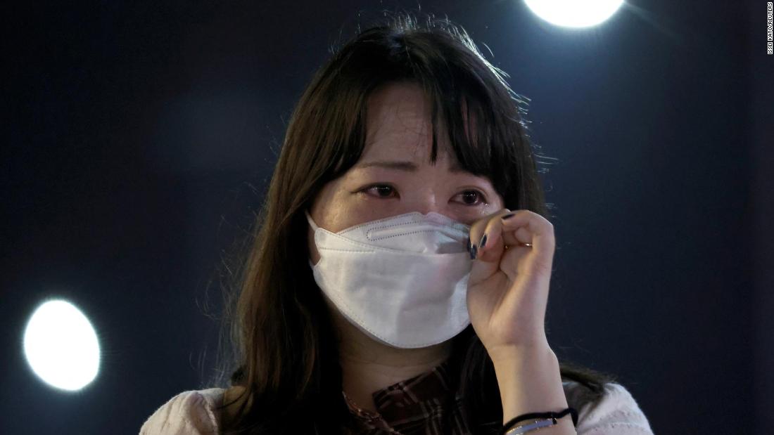 A woman cries at the site where Abe was shot in Nara, Japan, on July 8.