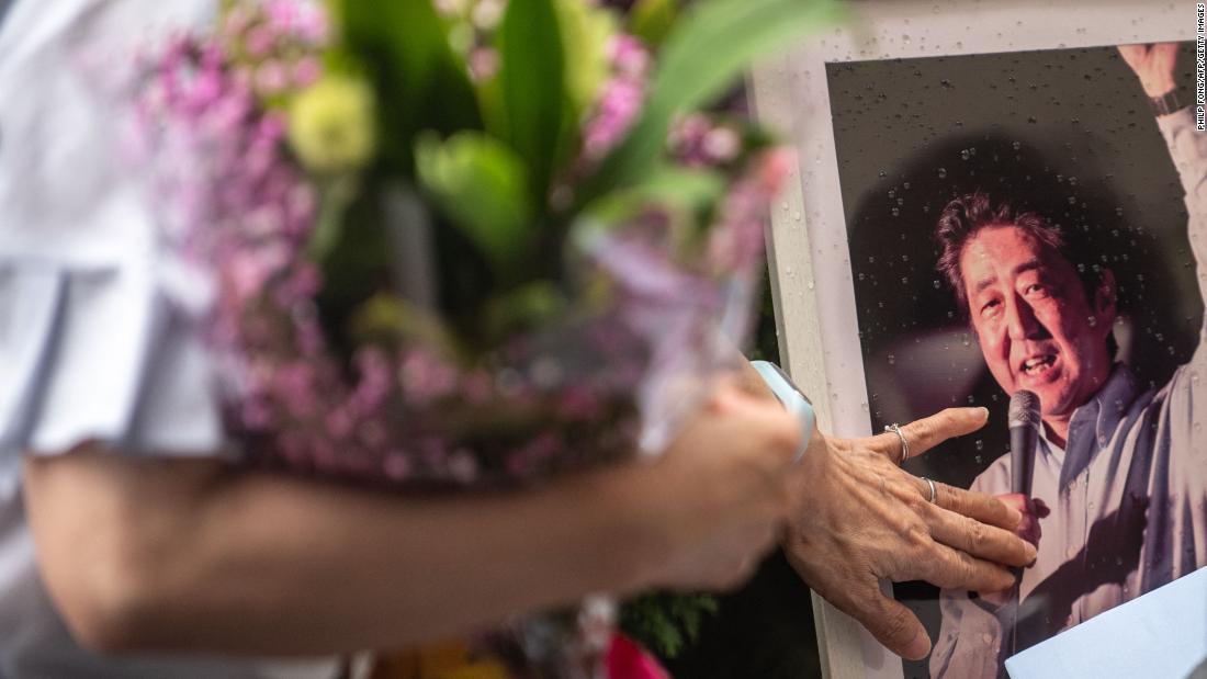 People line up to place flowers at the makeshift memorial in Nara.