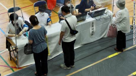 Voters receive their ballots during Japan&#39;s upper house elections at a polling station in Tokyo on July 10.